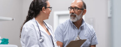 Doctor talking to patient holding clipboard