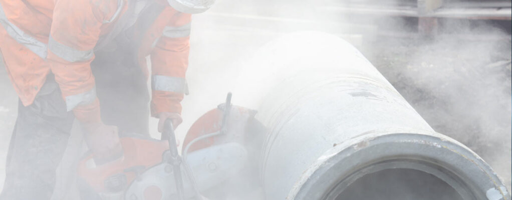 worker cutting asbestos-containing pipes