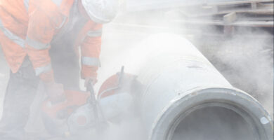 worker cutting asbestos-containing pipes