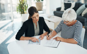 An older woman reviews paperwork with her attorney