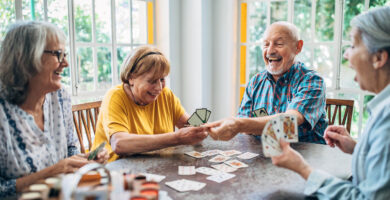 Group of people play cards together and laugh