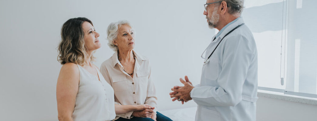 A doctor speaks with an elderly patient and her family member