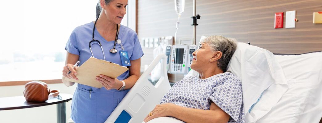 A female patient speaks to her doctor from a hospital bed