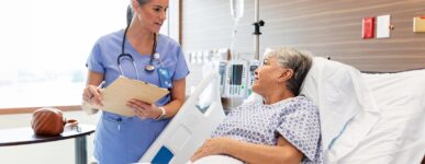 A female patient speaks to her doctor from a hospital bed