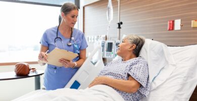 A female patient speaks to her doctor from a hospital bed