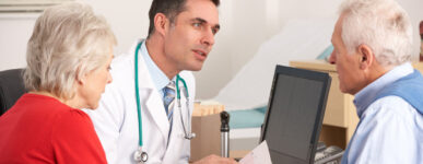 Mesothelioma doctor talking to an older male patient and his wife