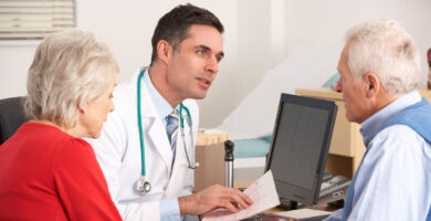 Mesothelioma doctor talking to an older male patient and his wife