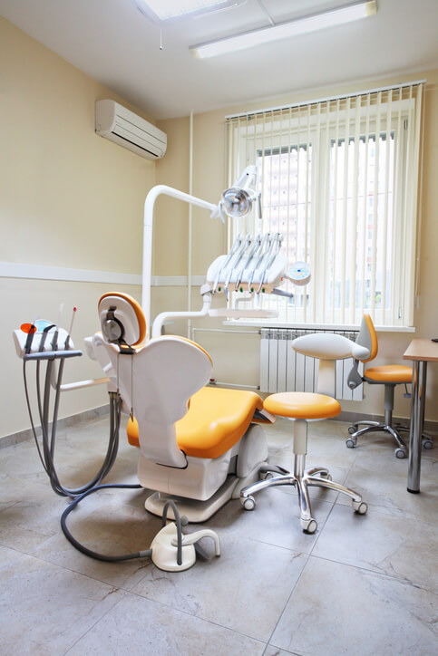 A clean, empty dentist's office with yellow colors