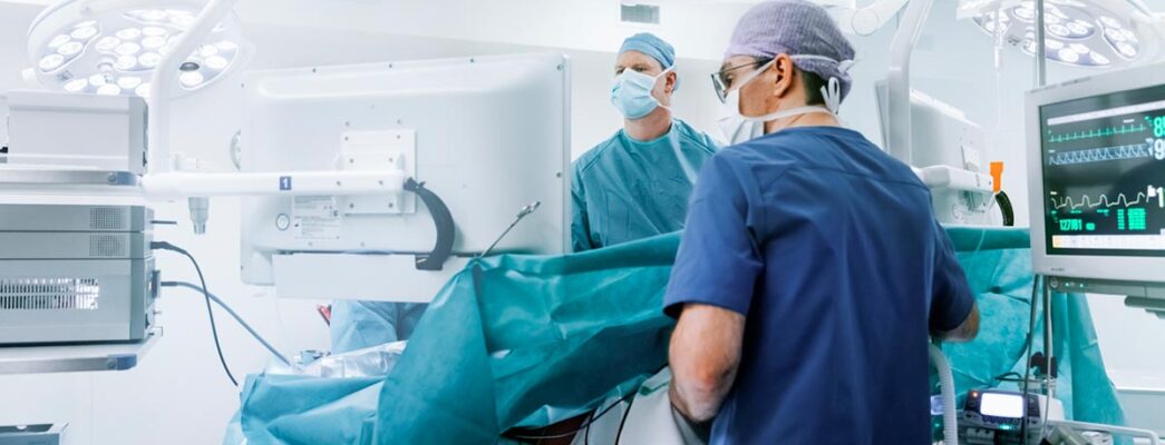 Doctors in blue scrubs work on a patient in an operating room