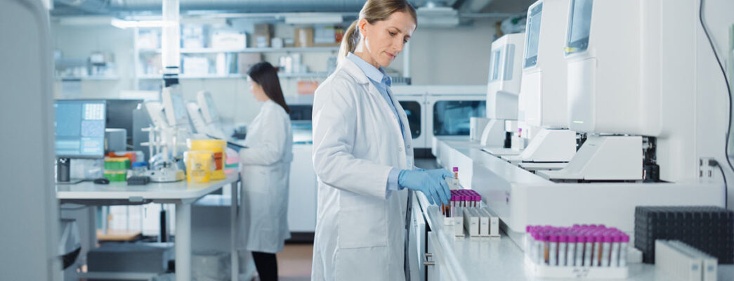 A lab technician examines multiple sets of vials