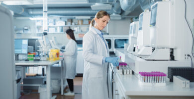 A lab technician examines multiple sets of vials
