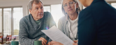 An older man and woman meet with an attorney