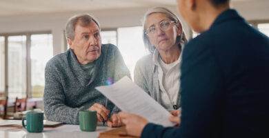 An older man and woman meet with an attorney