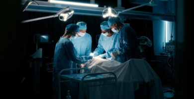 A group of surgeons work on a patient in an operating room