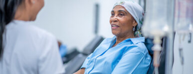 A female patient speaks with a nurse as she receives an infusion of immunotherapy for mesothelioma