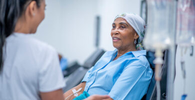 A female patient speaks with a nurse as she receives an infusion of immunotherapy for mesothelioma