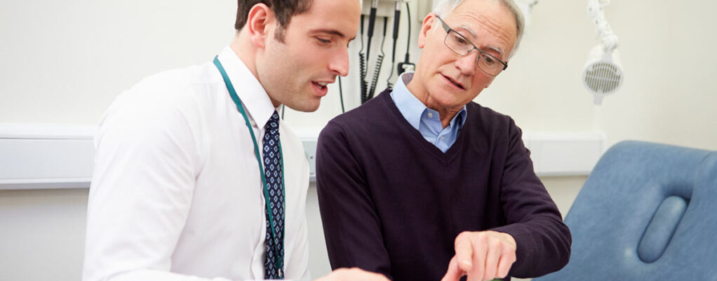 A mesothelioma patient discusses his progress with a doctor inside an exam room
