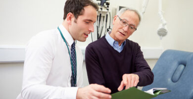 A mesothelioma patient discusses his progress with a doctor inside an exam room