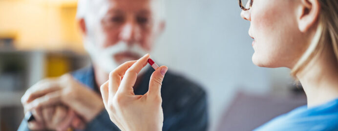 Mesothelioma doctor holding a pill up to a patient