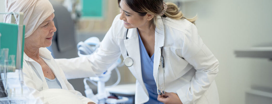 Elderly female patient talks to her doctor while receiving an immunotherapy infusion