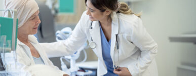 Elderly female patient talks to her doctor while receiving an immunotherapy infusion