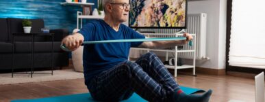 Older man using an exercise band at home