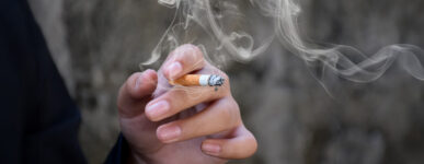 Close-up of a hand holding a lit cigarette